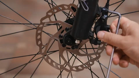 Removing a disc brake caliper from a bicycle suspension fork Stock Footage 280482440