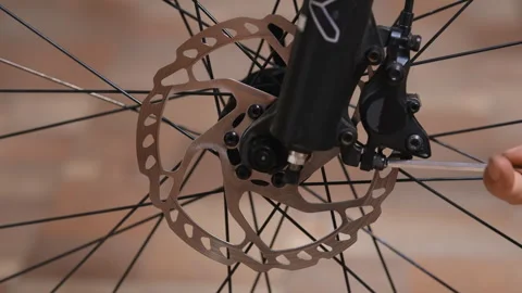 Removing a disc brake caliper from a bicycle suspension fork Stock Footage 280487365
