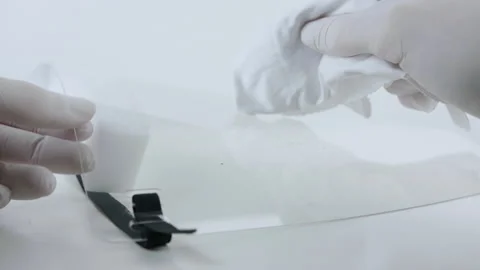 Removing droplets from a coronavirus face shield for use in ER. Video stock 130333872