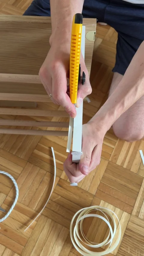 Removing excess edge banding with utility knife from laminated furniture board Stock Footage 340071907