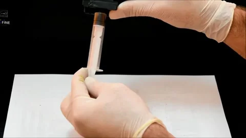 Removing Excess Ink from Cartridge Using Syringe and Gloved Hands Video stock 321180680