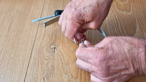 Removing an Extension Spring from a Metal Hook by Hand Safely Stock Footage 340541033