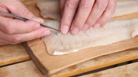 Removing fishbones from the cod fillet. 3807 Stock Footage 144667445