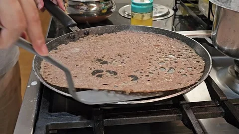 Removing Freshly Cooked Dosa from Pan on Kitchen Stove Stock Footage 344040955