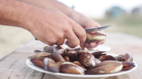 Removing freshly cooked mussels from shells Stock Footage 63306838