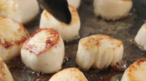 Removing fried scallops from a pan Video stock 24662888