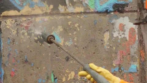 Removing Graffiti from Urban Wall Using Pressure Washer Stock Footage 348241204