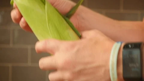 Removing the husk from a sweetcorn Stock Footage 115058032