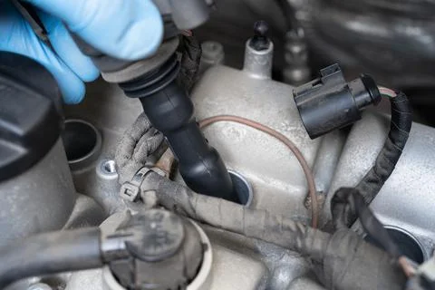 Removing ignition coil in car engine bay. Stock-Fotos