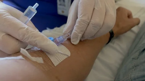 Removing intravenous drip and doing a saline flush Stockbeeldmateriaal 91862216