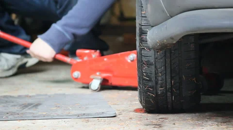 Removing jack from under car Stock Footage 54196420