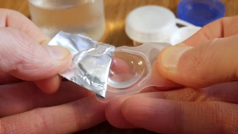 Removing the lens from the package Stock Footage 73378404