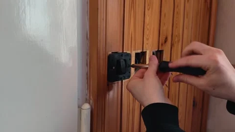 Removing light switch during home renovation, electrician unscrewing wall 库存影片 333788765