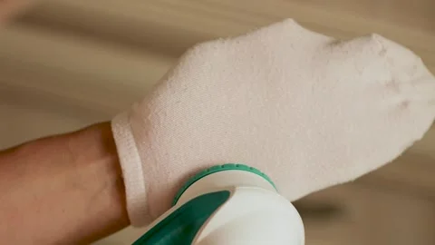 Removing lint from a pink sock  Stock Footage 308641599