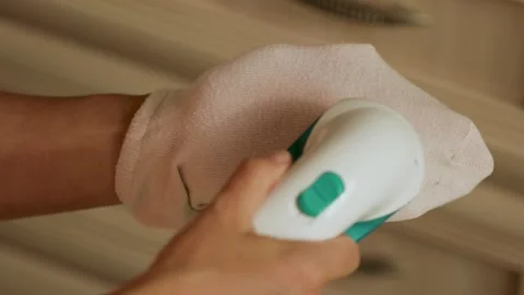 Removing lint from a pink sock  Stock Footage 308641613