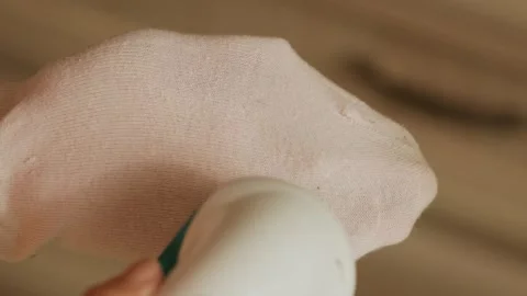 Removing lint from a pink sock  Stock Footage 308641614