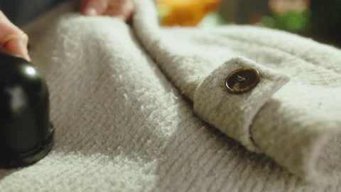 Removing Lint from a Wool Coat with Fabric Shaver Stock-Footage 330922130