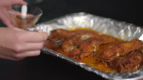 Removing the liquid from grilled ribs. Concept of preparing ribs in an oven Stock Footage 136130975
