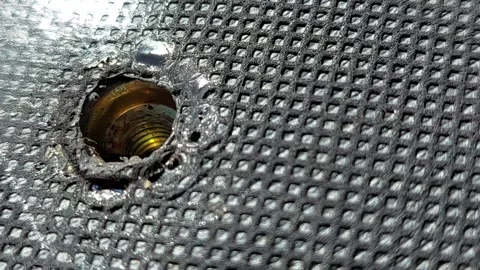 Removing a metal bolt from a threaded hole macro shot Stock Footage 334569355