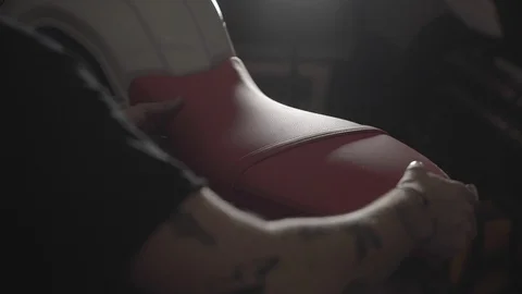 Removing a motorcycle seat in a workshop Stock Footage 125446205