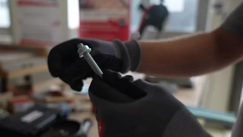 Removing a nut from a metal bolt in a professional workshop, highlighting Stock Footage 336726782