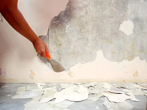 Removing old paint from the old wall by hand with a metal spatula. Painting P Foto stock