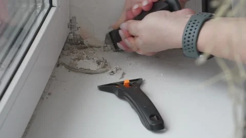 Removing Old Sealant from Window Frame during Renovation Stock Footage 335941436