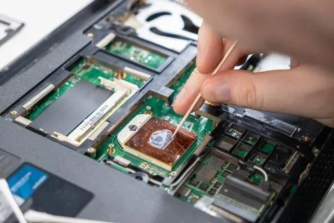 Removing old thermal paste from a processor chip during PC maintenance Stock Photos