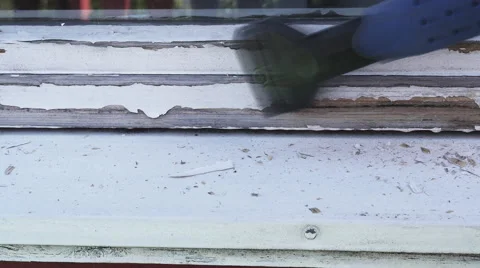 Removing old white paint from window frame before painting Stock Footage 53572004