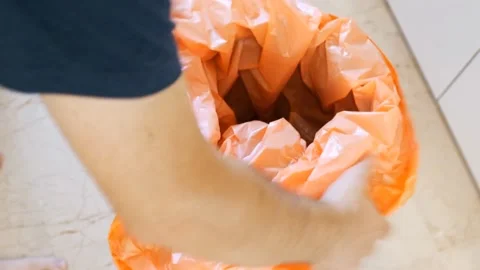 Removing an Orange Garbage Bag from a Bin Stock Footage 314303574