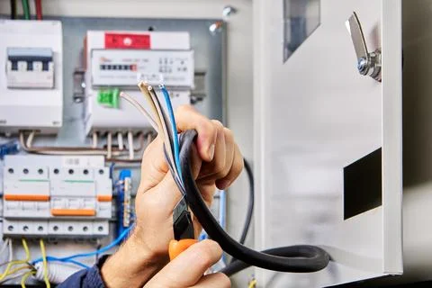 Removing outer sheath of PVC insulation from power cable for connection to .. 写真素材