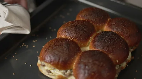 Removing from the oven and placing on the table nicely baked beef sliders. Stock Footage 135465430