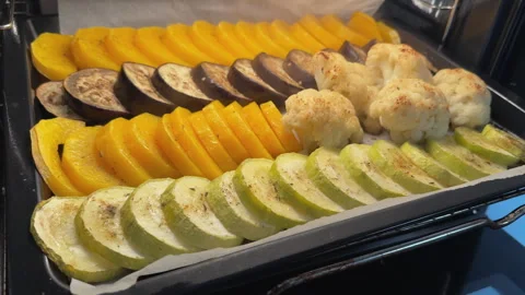 Removing parchment paper from baked vegetables in oven Stock Footage 340237790