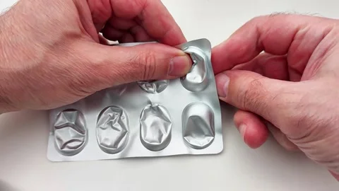 Removing Pill from Blister Pack on White Surface During Daily Routine Video stock 326896871