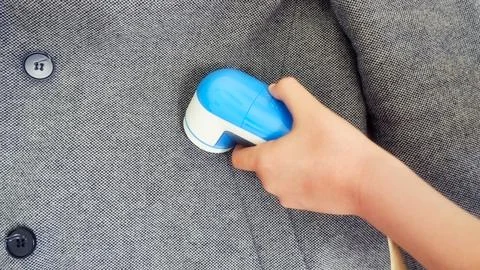 Removing pilling from a gray jacket Stock Photos