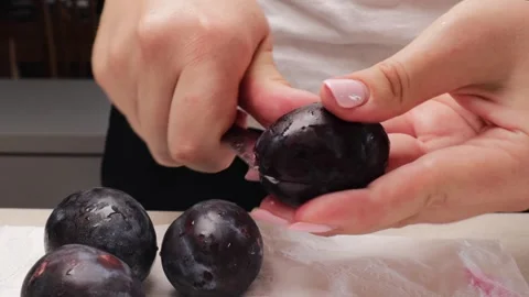 Removing pits from plums by hand Stock Footage 316677074