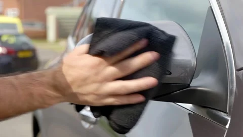 Removing polish from silver SUV mirror with black microfibre cloth towel Stock Footage 319013988