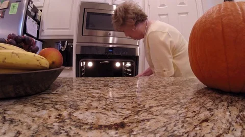 Removing a pumpkin pie from the oven and setting it on counter, 4K Stock Footage 81603754