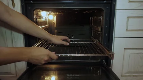 Removing the rack from an open oven Stock Footage 340016048