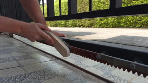 Removing Rust from Metal Gate with Wire Brush Close Up Stockbeeldmateriaal 332889852