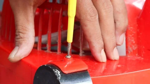 Removing a screw from a plastic electric fan Stock Footage 341536551