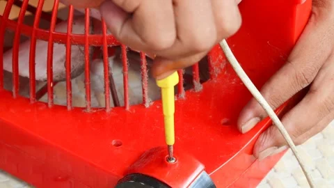 Removing a screw from a plastic electric fan Stock Footage 341536562