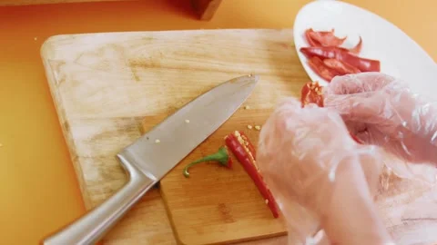 Removing seeds and membrane from a split red chili pepper, high-angle detail, 4K 库存影片 341122441