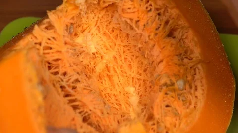 Removing seeds from a pumpkin with a spoon Stock Footage 81391133