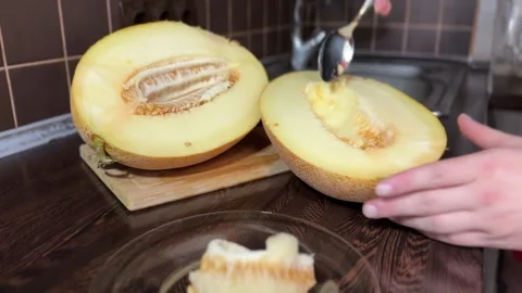 Removing Seeds from Ripe Melon with Spoon Stock Footage 315991745