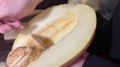 Removing Seeds from Ripe Melon with Spoon Stock Footage 315991756