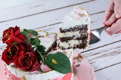 Removing a slice of chocolate cake covered with Swiss meringue buttercream. T Stock Photos