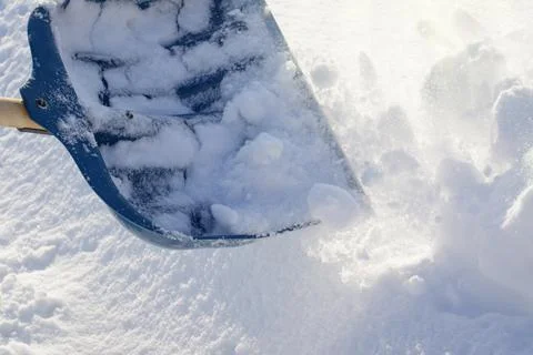 Removing snow in the backyard after a heavy snow blizzard with a shovel Stock Photos