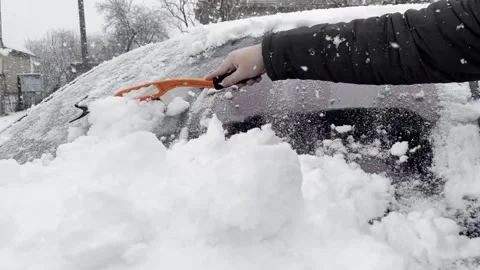 Removing snow off a car front windscreen Stock Footage 230234899