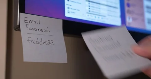 Removing Sticky Notes with Password Reminders from Monitor Stockbeeldmateriaal 74482199